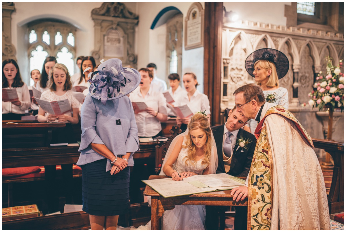 Bride and groom sign the register after their Wedding ceremony in St Mary's Church in Cheshire.