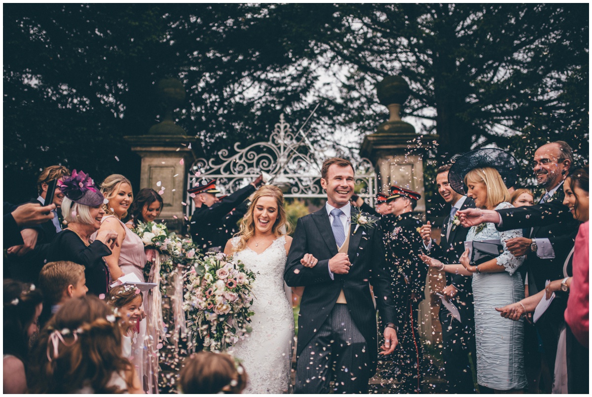 Wedding guests all throw confetti at the bride and groom outside St Mary's Church in Cheshire.