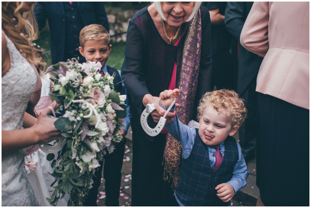 Cute little wedding guest gives a horseshoe to the bride.