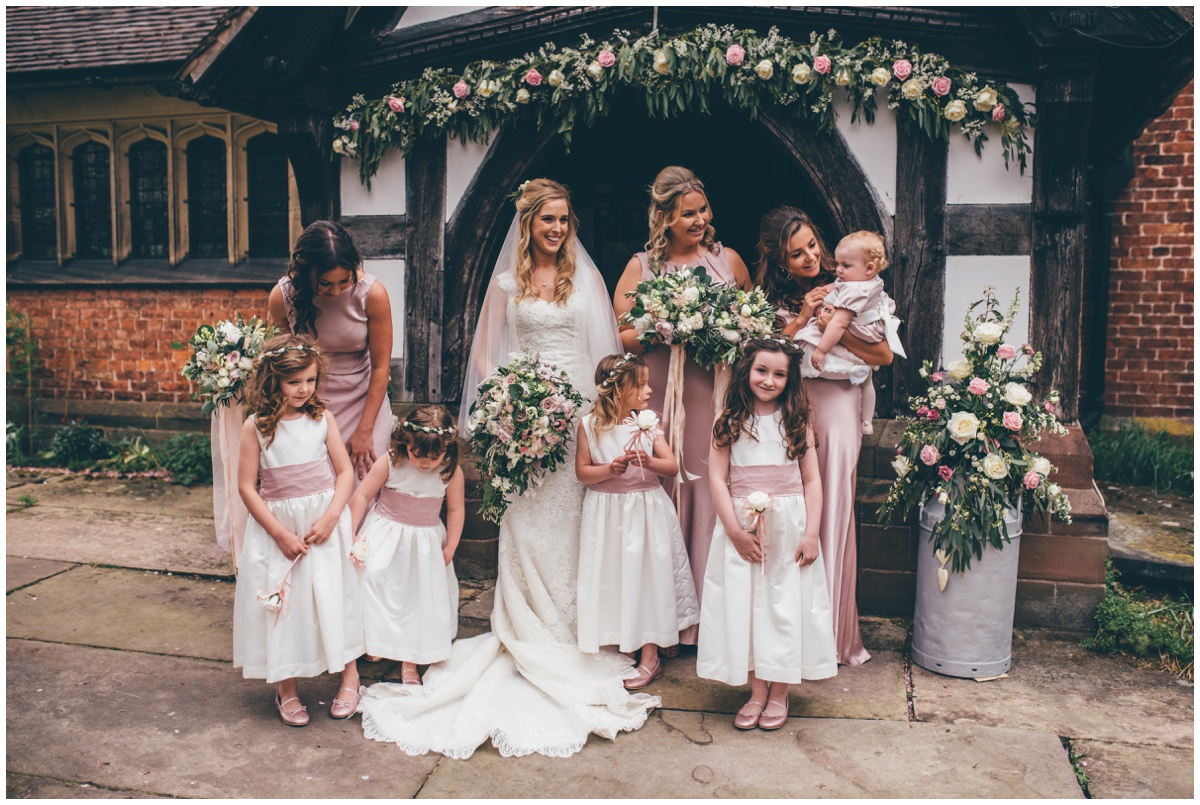 The bride and her bridesmaids pose for wedding photographs outside St Mary's Church in Cheshire.
