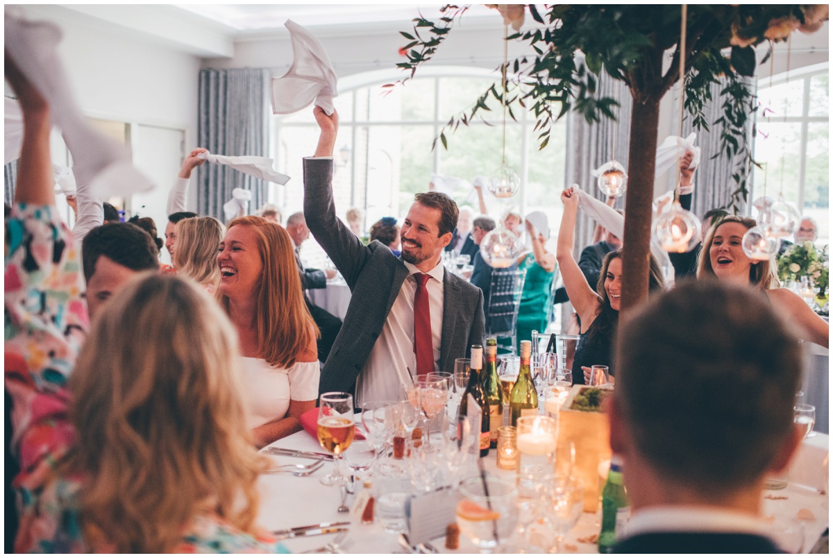 Wedding guests welcome the bride and groom into their wedding breakfast.