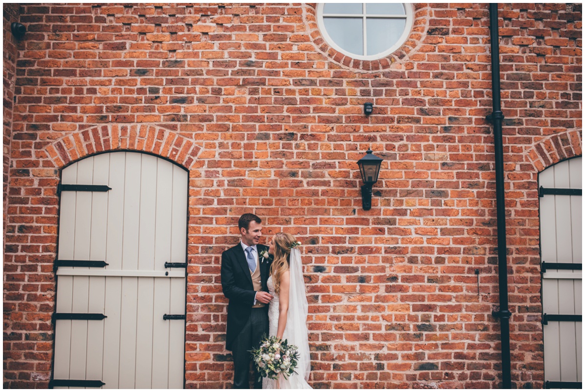 Bride and groom stand against the wall at Merrydale Manor.