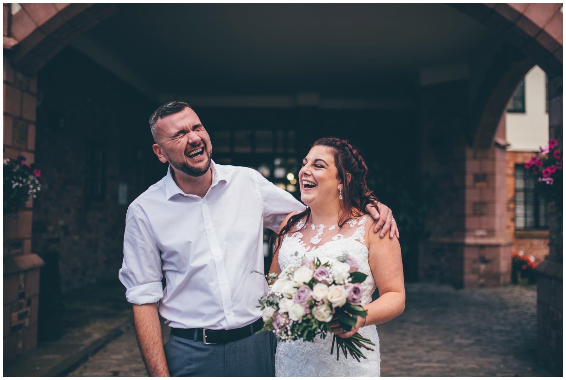 Bride and Groom crack up laughing together after their wedding at Crabwall Manor just outside Chester in Cheshire.
