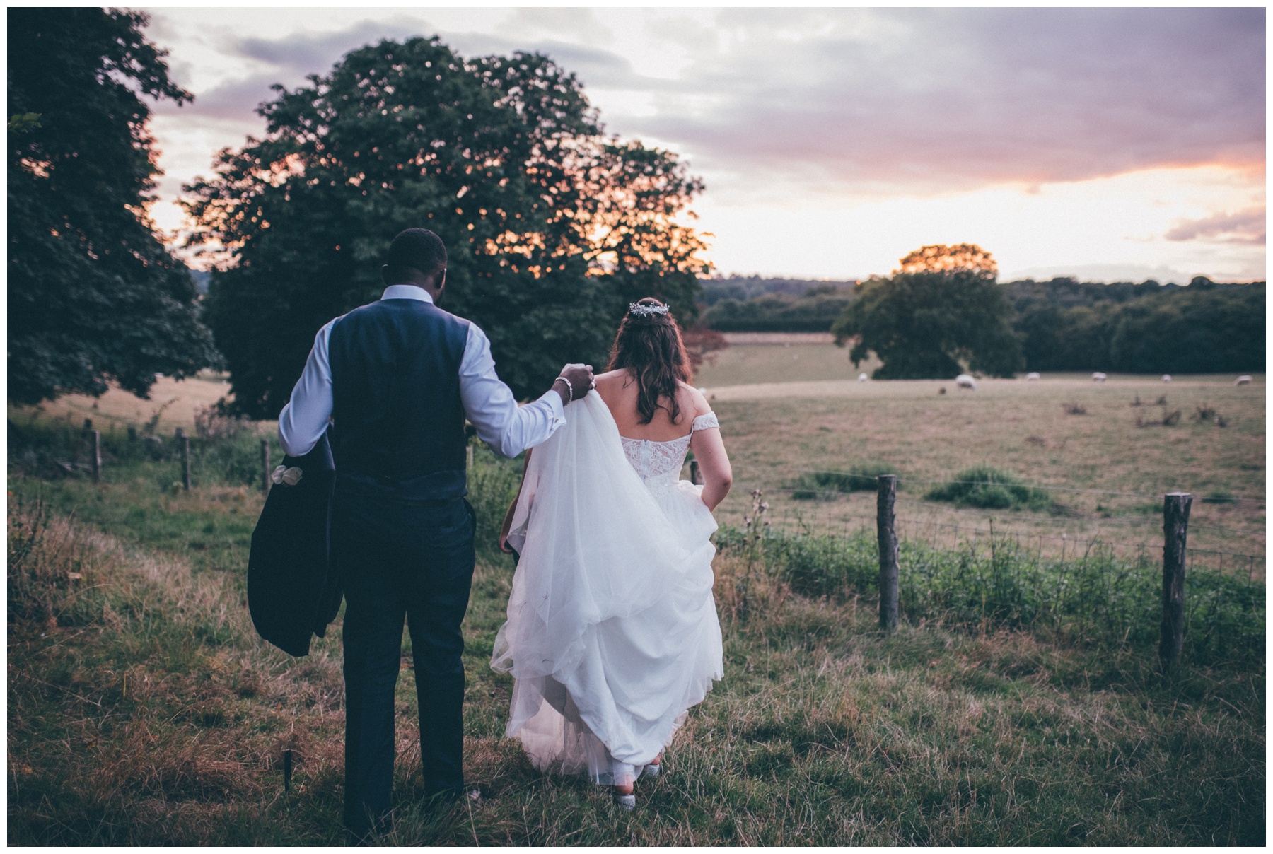 Bride and groom walk off together int the sunset at Gaynes Park, wedding venue near London.