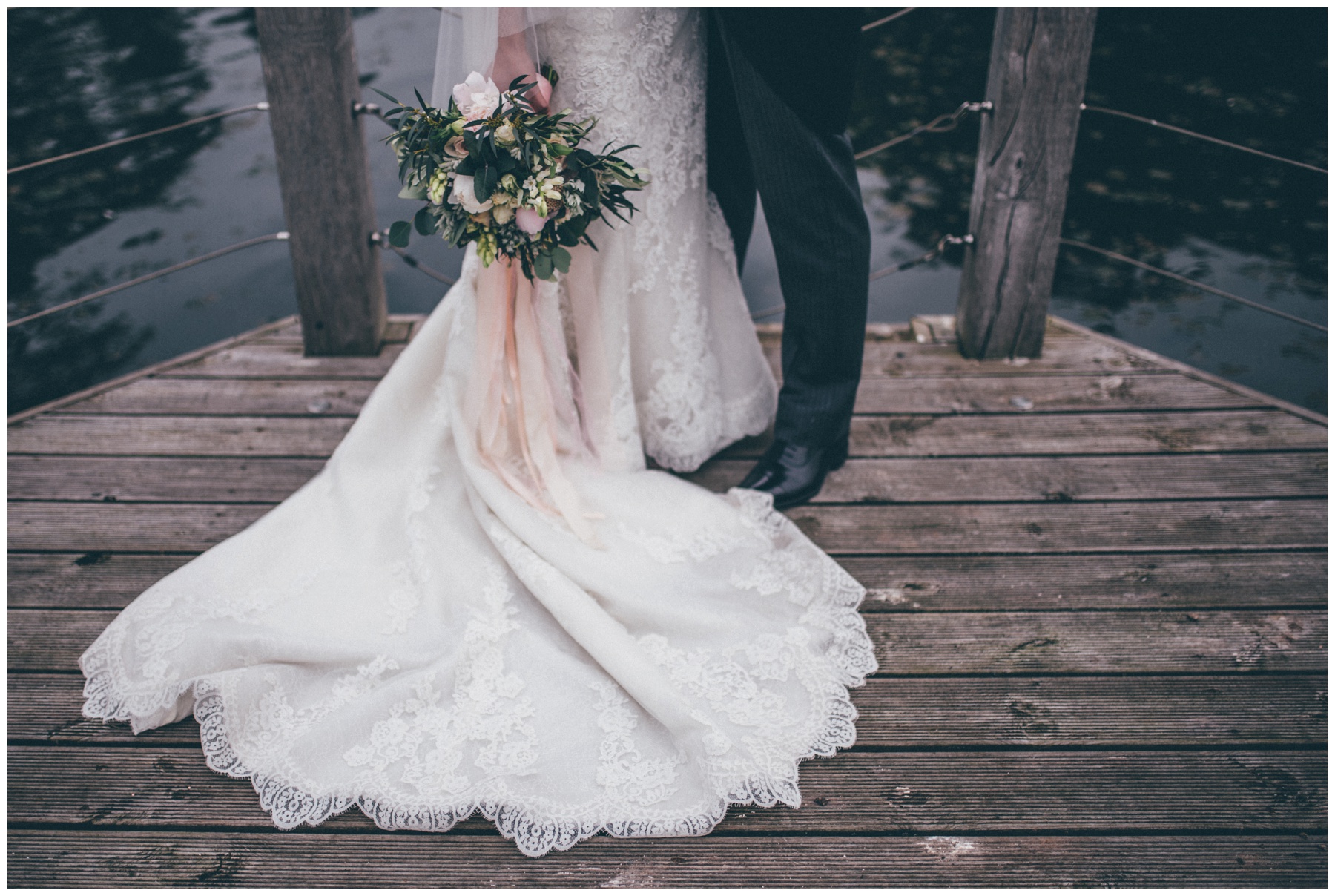 Bride and groom stand together with Red Floral flowers at Cheshire wedding at Merrydale Manor.