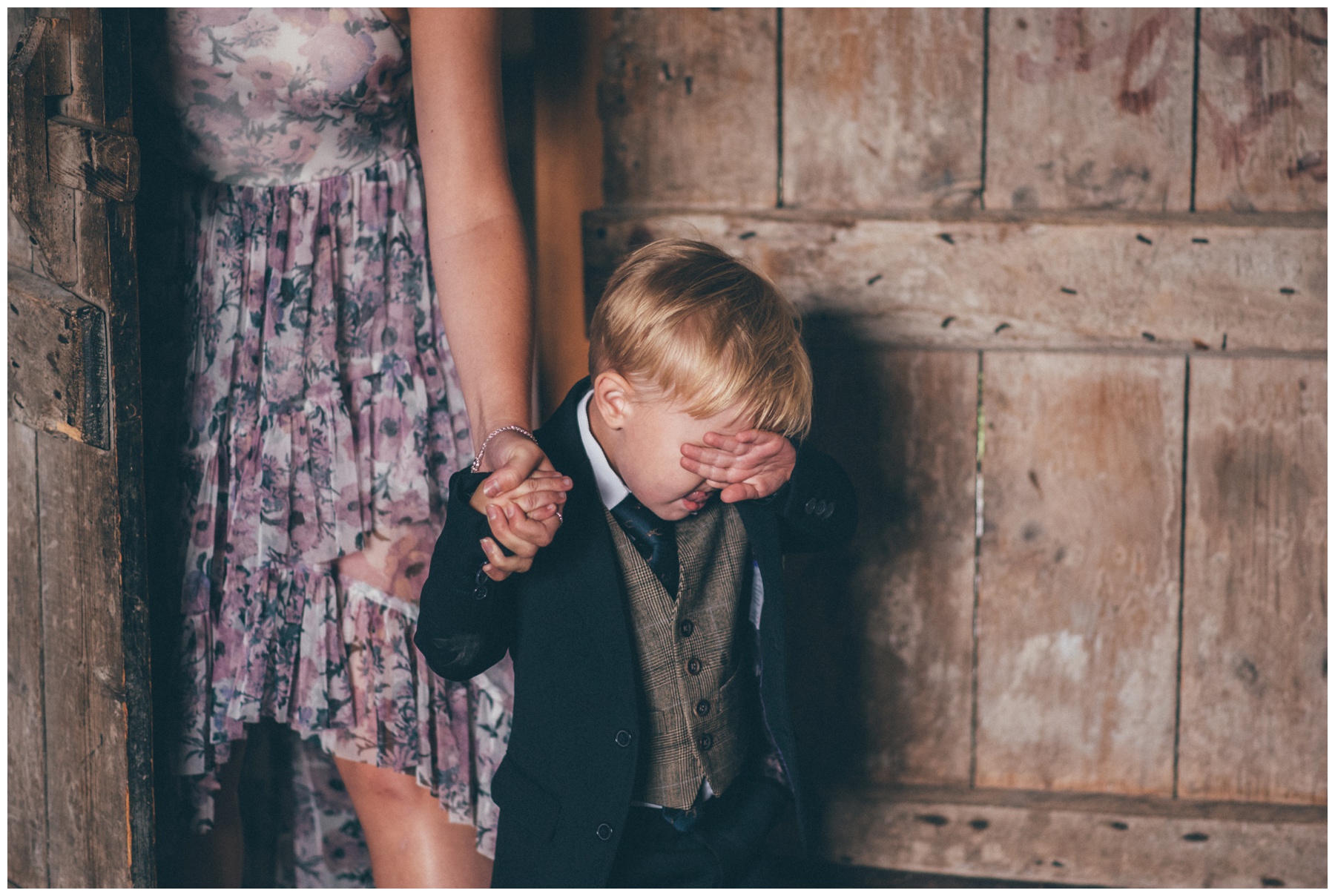 Cute little pageboy hides his face from all the guests shyly at Askham Hall.