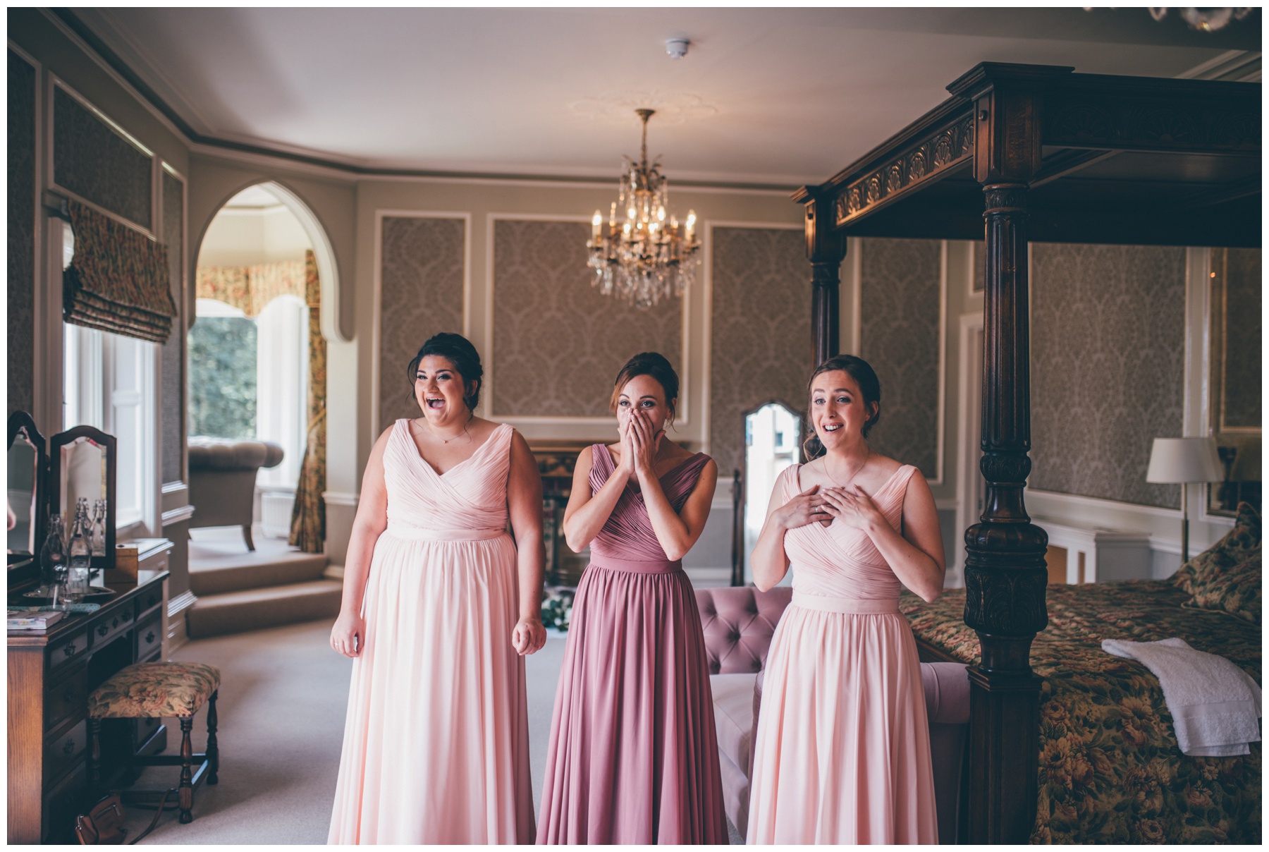 Bridesmaids reaction to seeing the bride in her dress for the first time at Tilstone House in Cheshire.