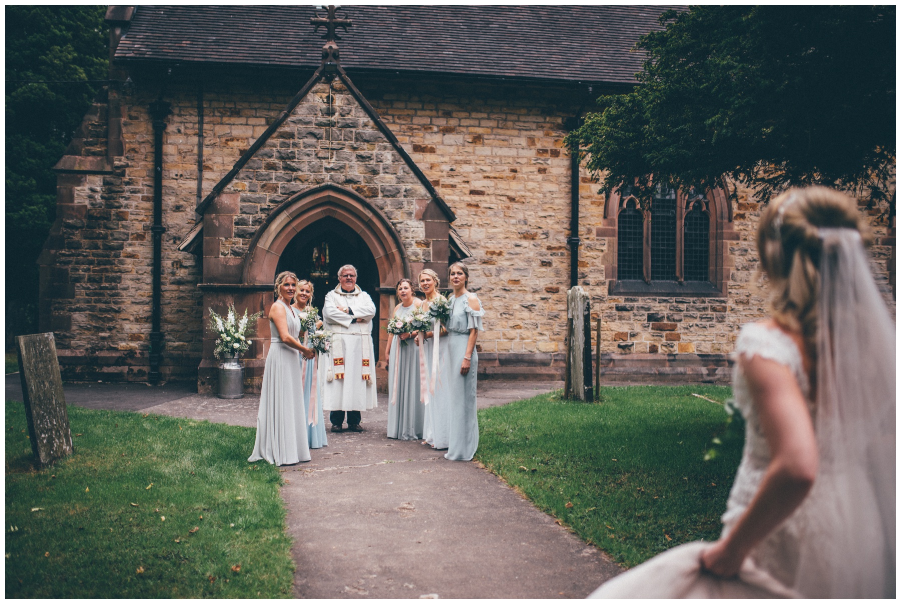 Bridesmaids and vicar await the brides arrival at church.