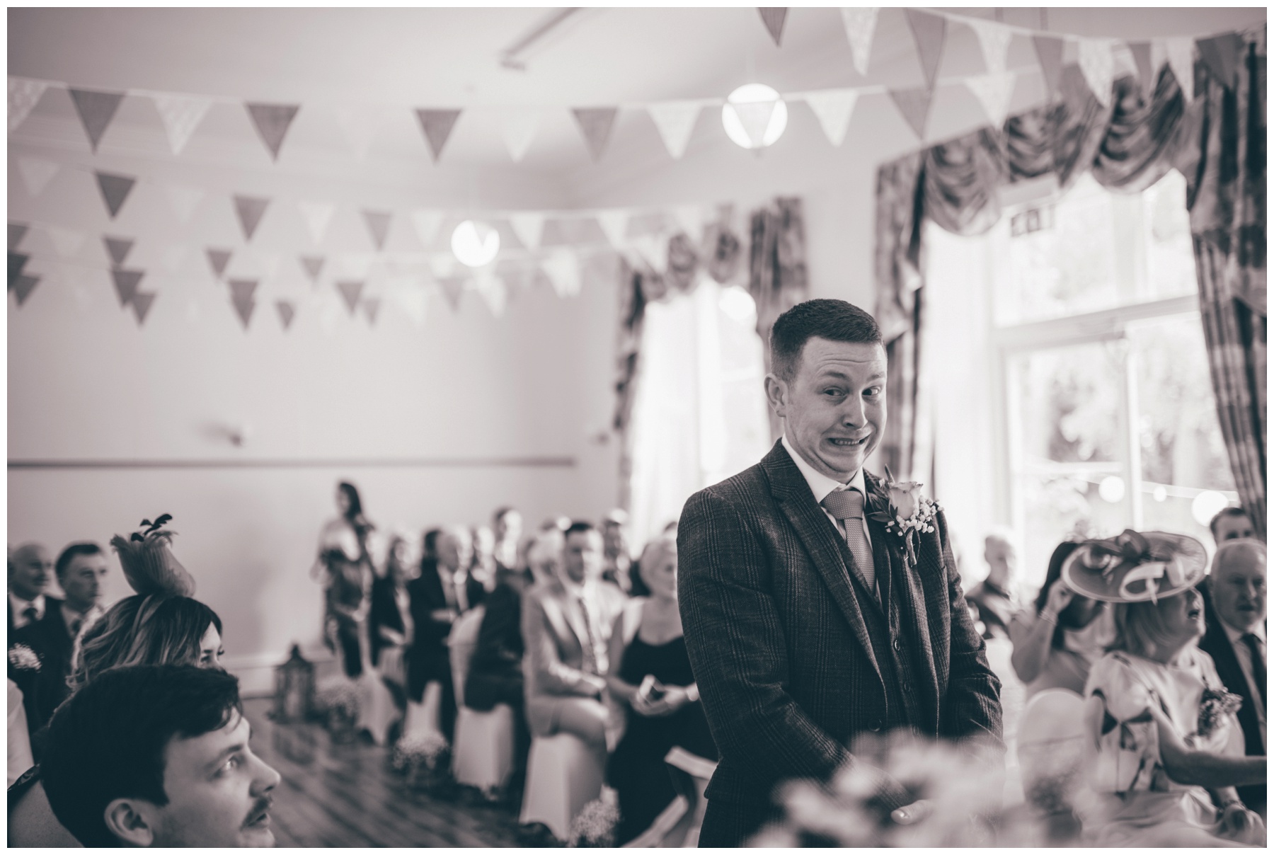Groom waits nervously for his bride to walk down the aisle at Trafford Hall.