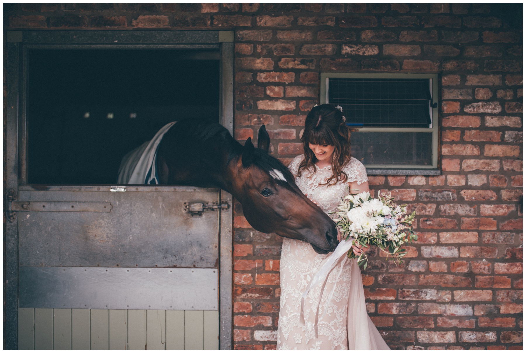 Bride strokes a horse at the Holford Estate wedding venue.