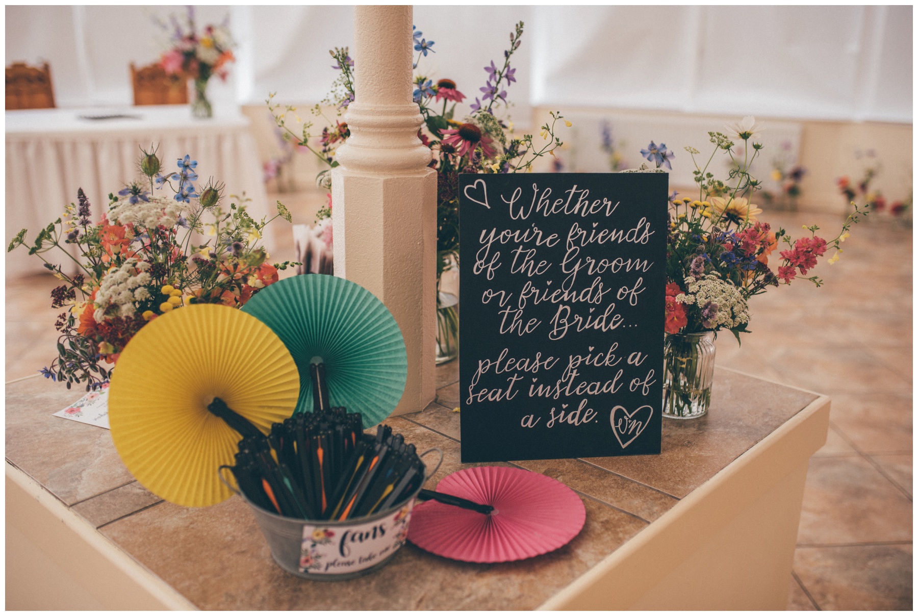 Bright coloured flowers and fans for a summer wedding at Combermere Abbey.