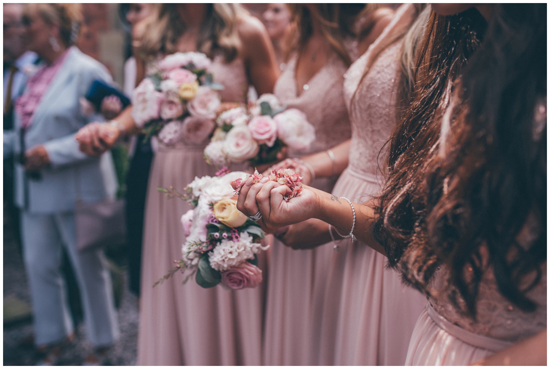 Detail shot of the bridesmaids holding confetti, getting ready to throw it at the bride and groom at new wedding venue, Tyn Dwr Hall in Wales.