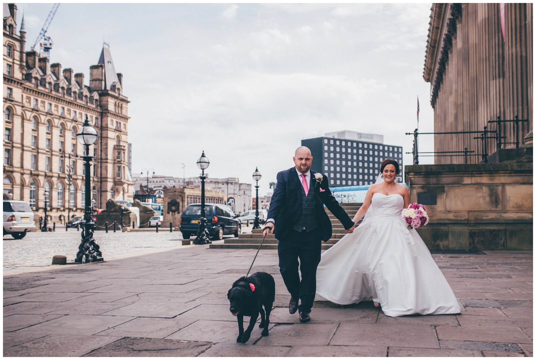 Bride and groom walk through Liverpool City Centre with their dog after their ceremony at St George's Hall.