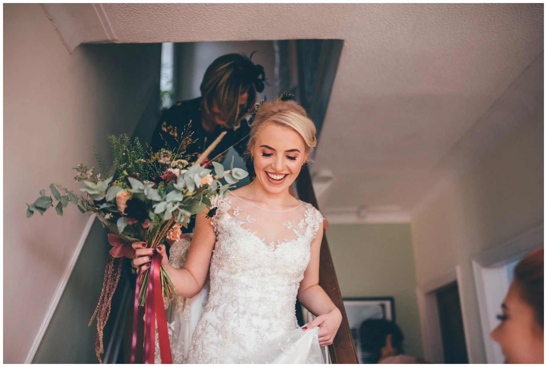 Beaming bride makes her way downstairs for her wedding.