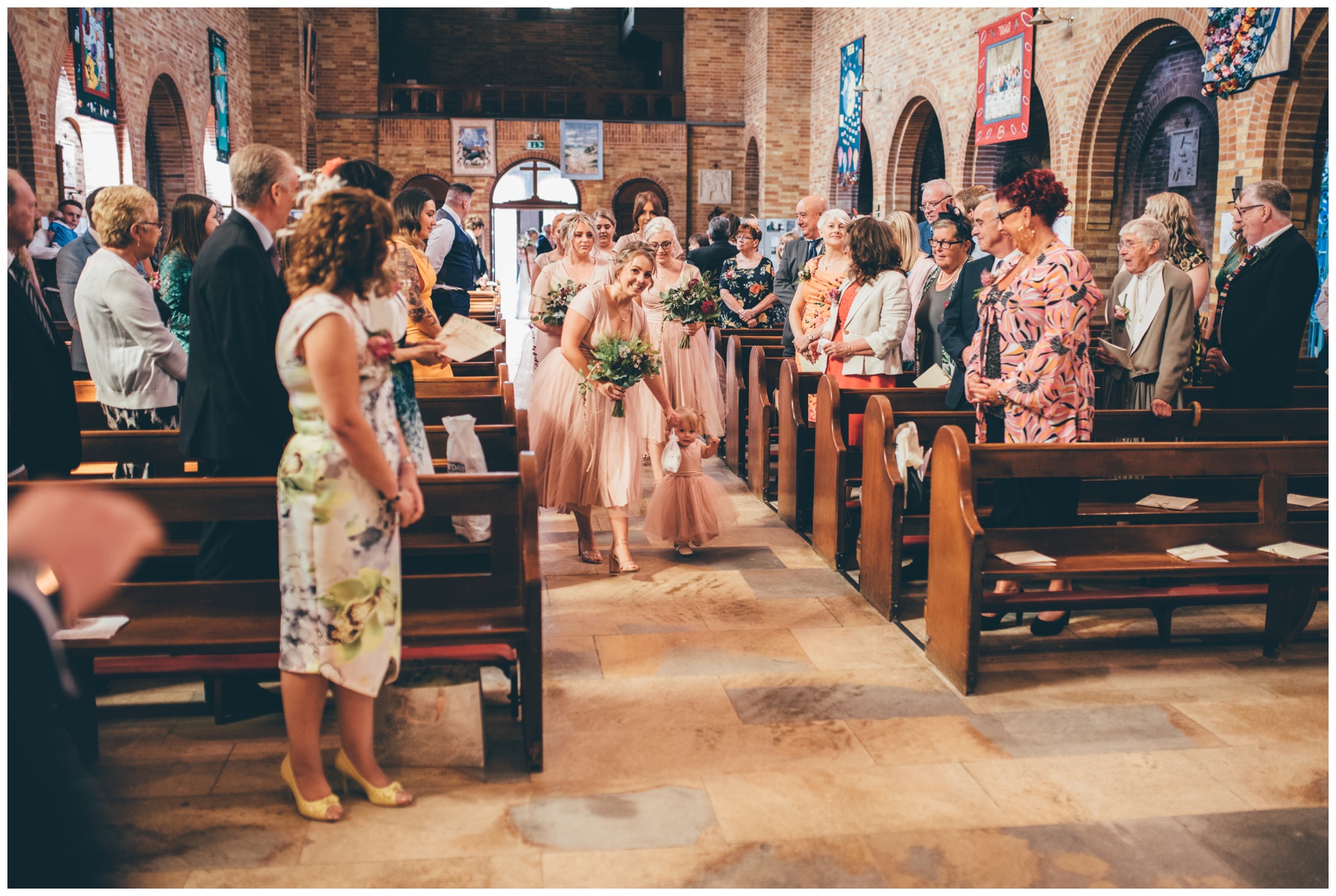 Bridesmaids make their way down the aisle at Sacred Heart in Sheffield.