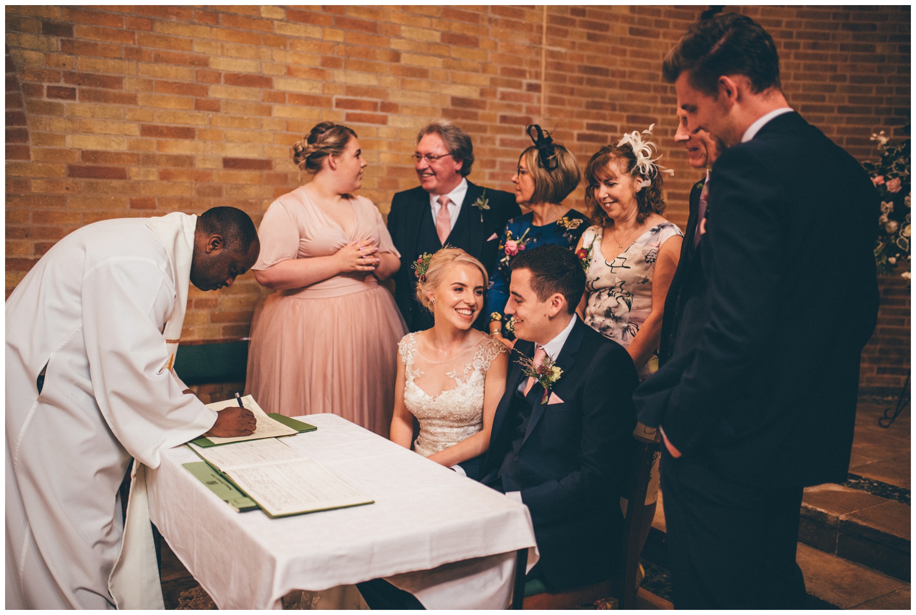 Bride and groom share a joke during the signing of their register at Sacred Heart church in Sheffield.