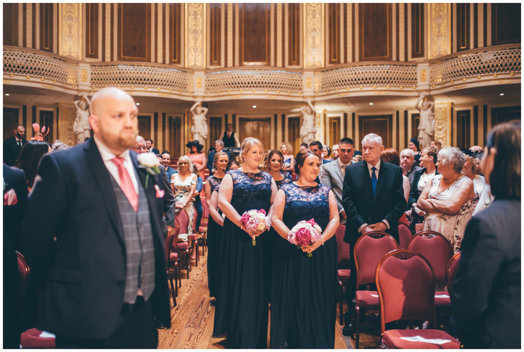 Bridesmaids walk down the aisle at St Georges Hall wedding in Liverpool City Centre.