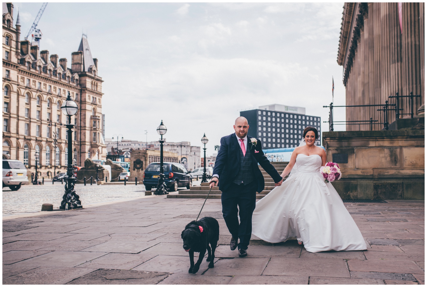 New husband and wife walk their dog in Liverpool city centre just after their wedding.