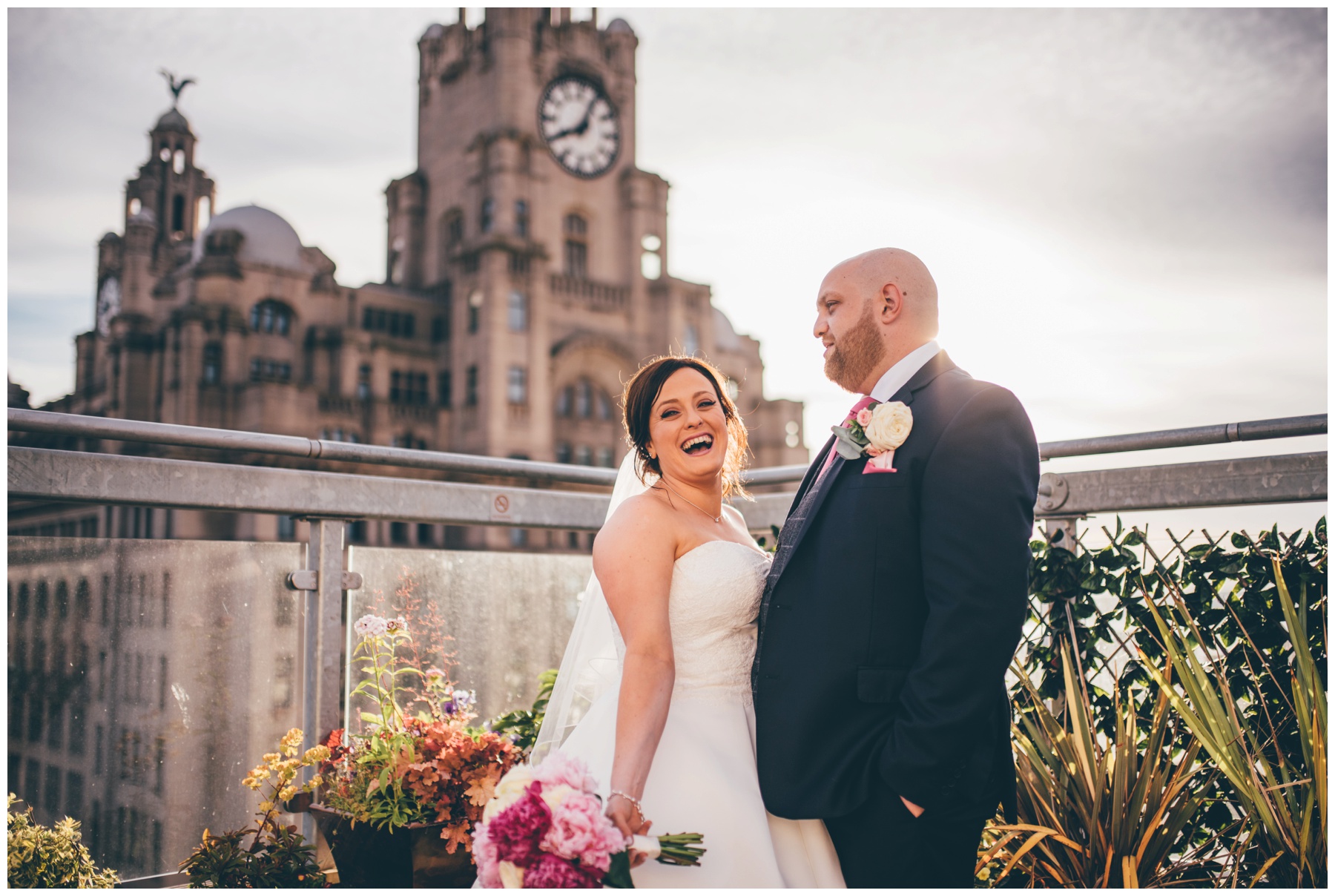 New bride and groom on the roof terrace at Liverpool Wedding venue, Oh Me Oh My, overlooking the Liver Building.