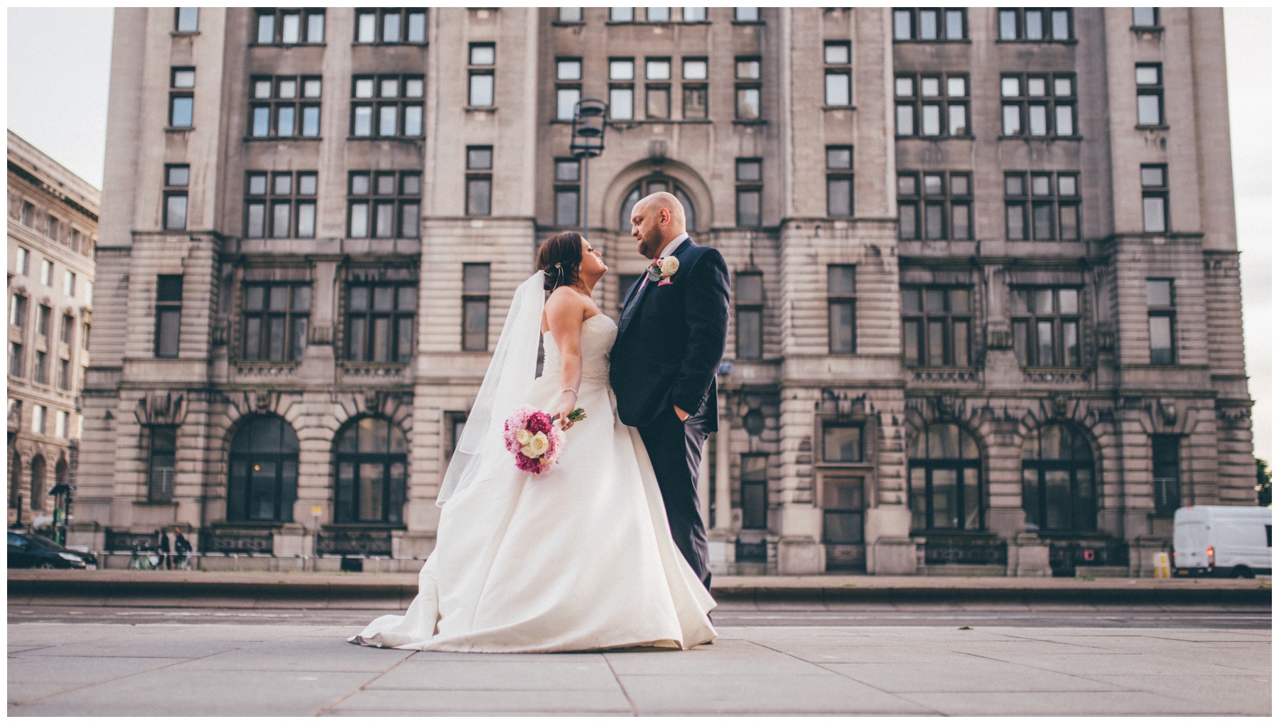 New bride and groom on the roof terrace at Liverpool Wedding venue, Oh Me Oh My, overlooking the Liver Building.