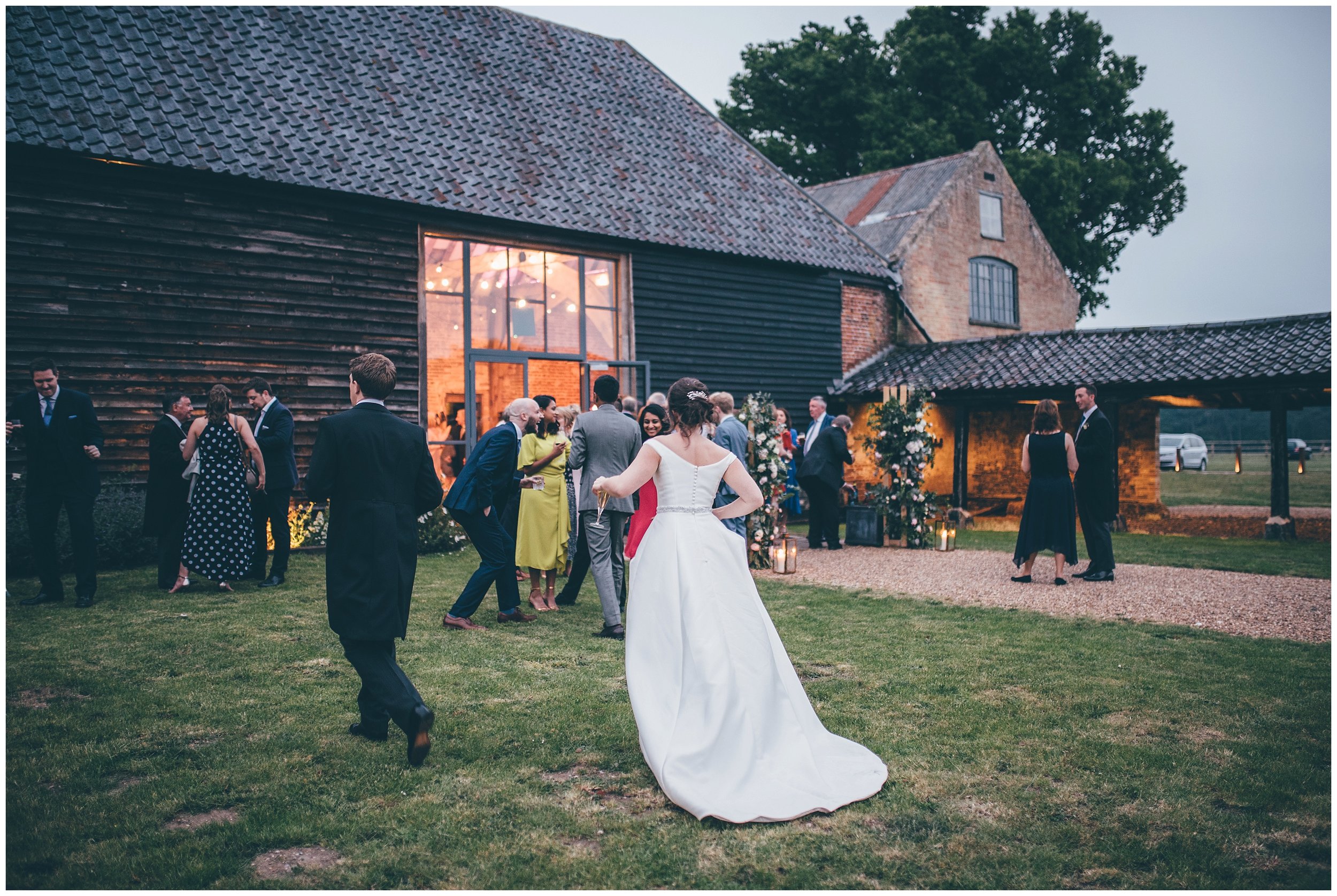 Bride and groom greet their evening guests at Henham Park wedding barns..