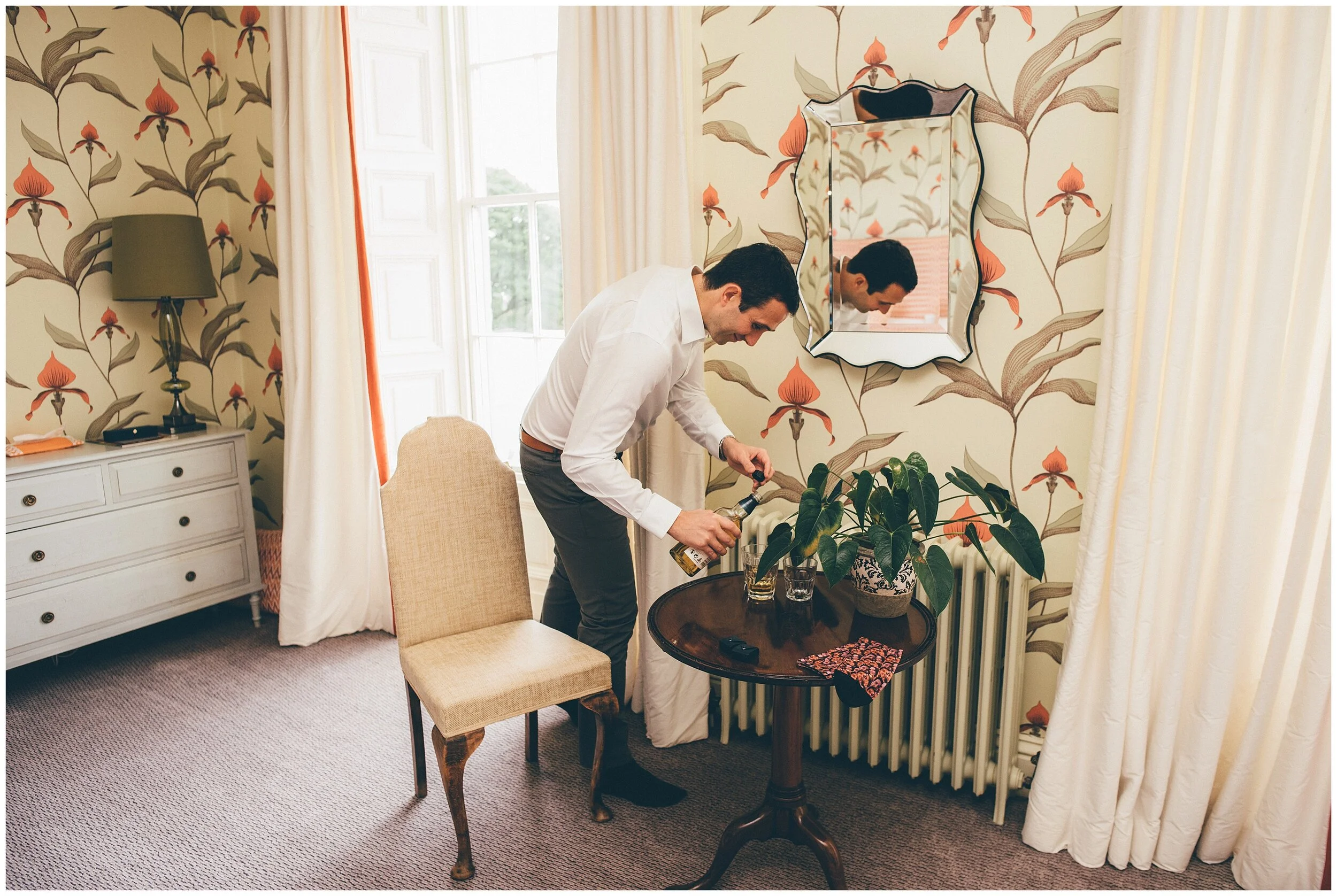 Best Man pours whisky for himself and his friend before the wedding at Silverholme Manor.