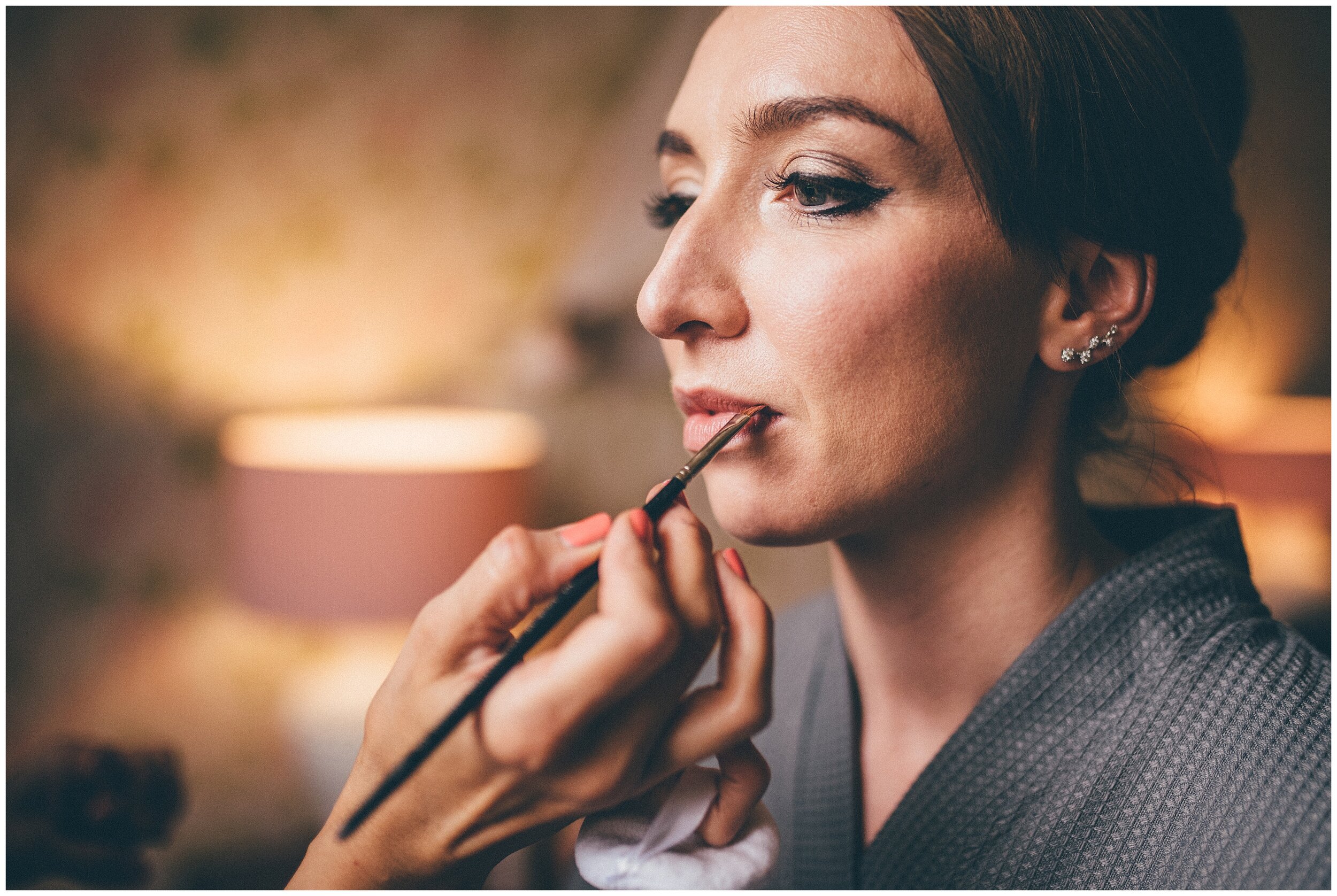 Bride gets her finishing touches done on her make-up before her Lake District wedding.