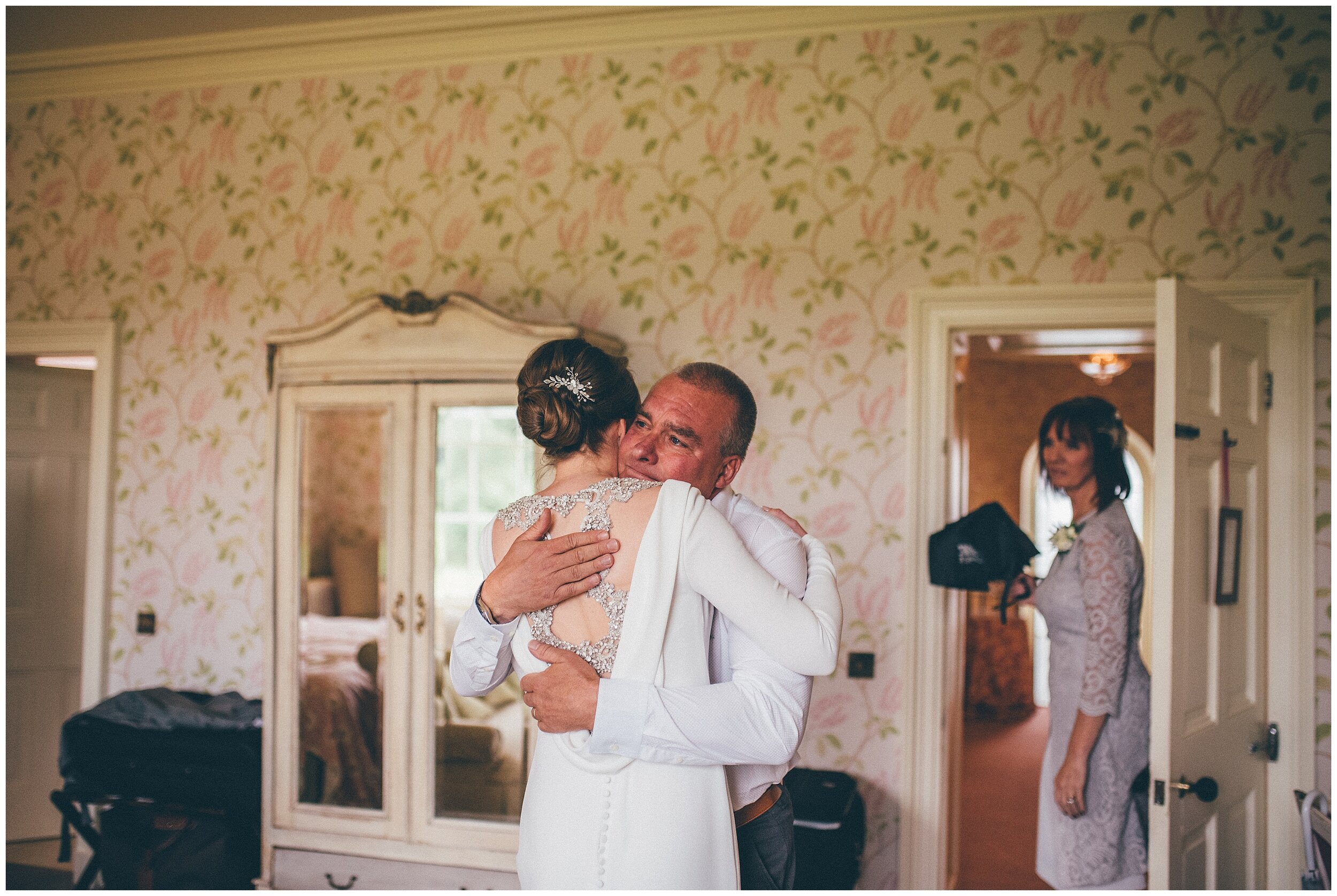 Bride's dad hugs her as he sees her as a bride for the first time.