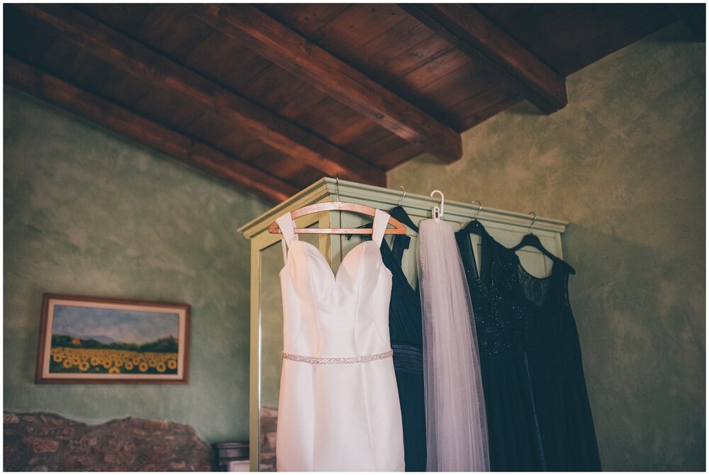 Wedding gown and bridesmaid dresses hung up in the bridal suite at Villa Bissiniga, Lake Garda.