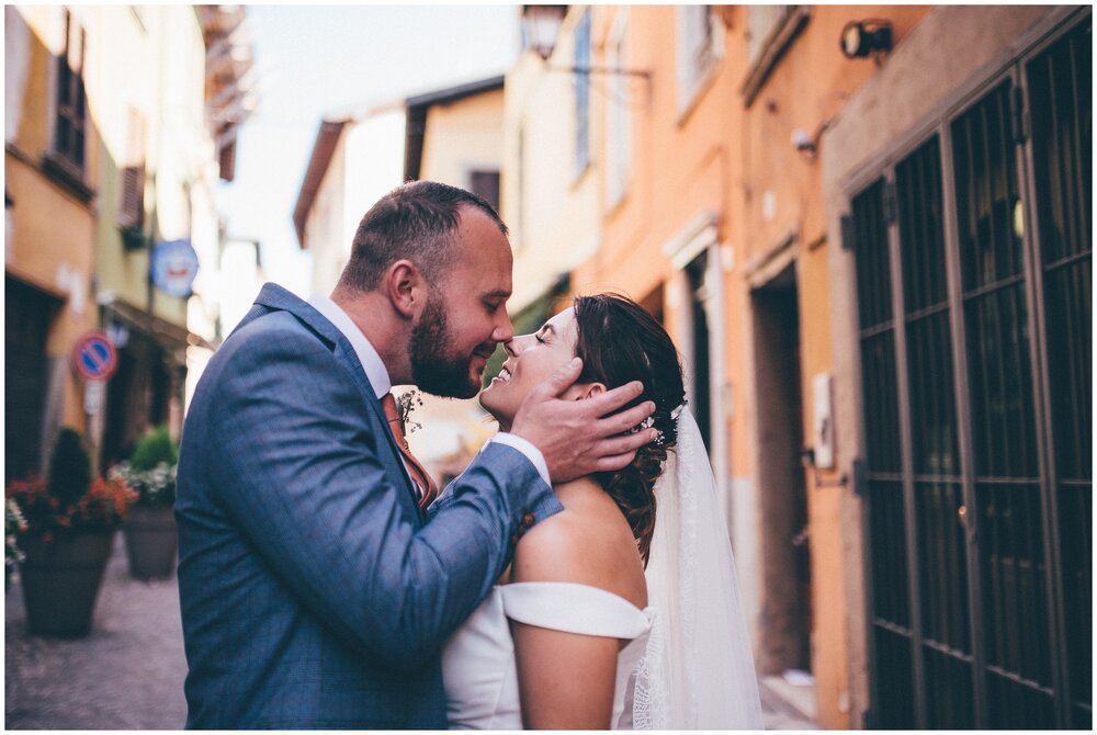 Newlyweds have their wedding photographs taken whilst strolling through Salo town centre in Lake Garda.