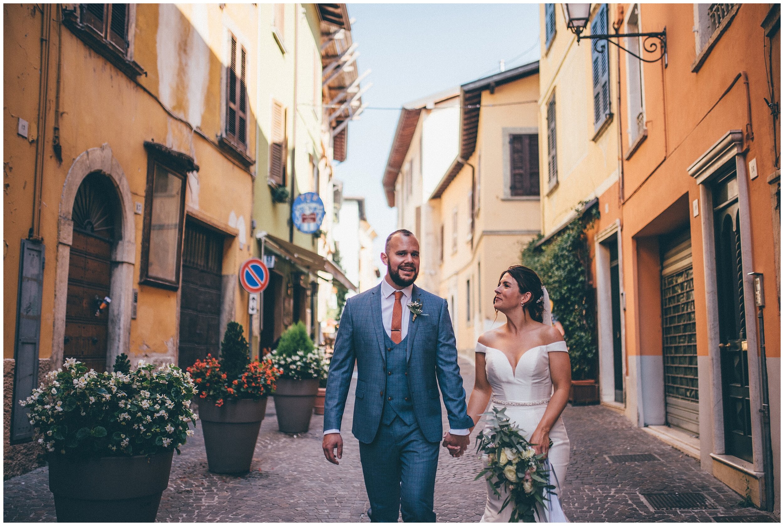 Newlyweds have their wedding photographs taken whilst strolling through Salo town centre in Lake Garda.