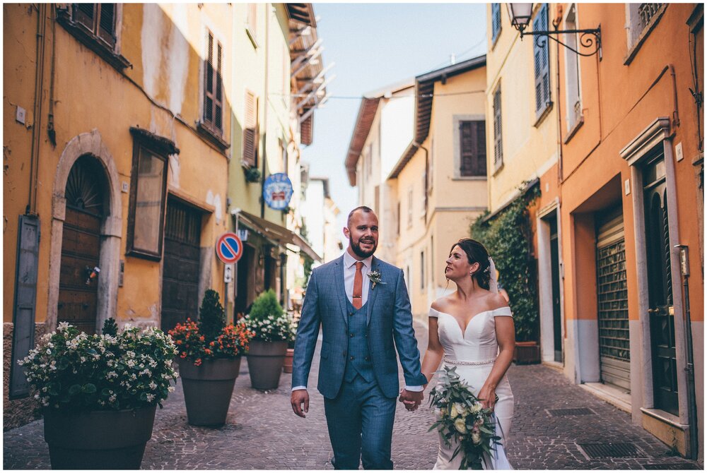 Newlyweds have their wedding photographs taken whilst strolling through Salo town centre in Lake Garda.