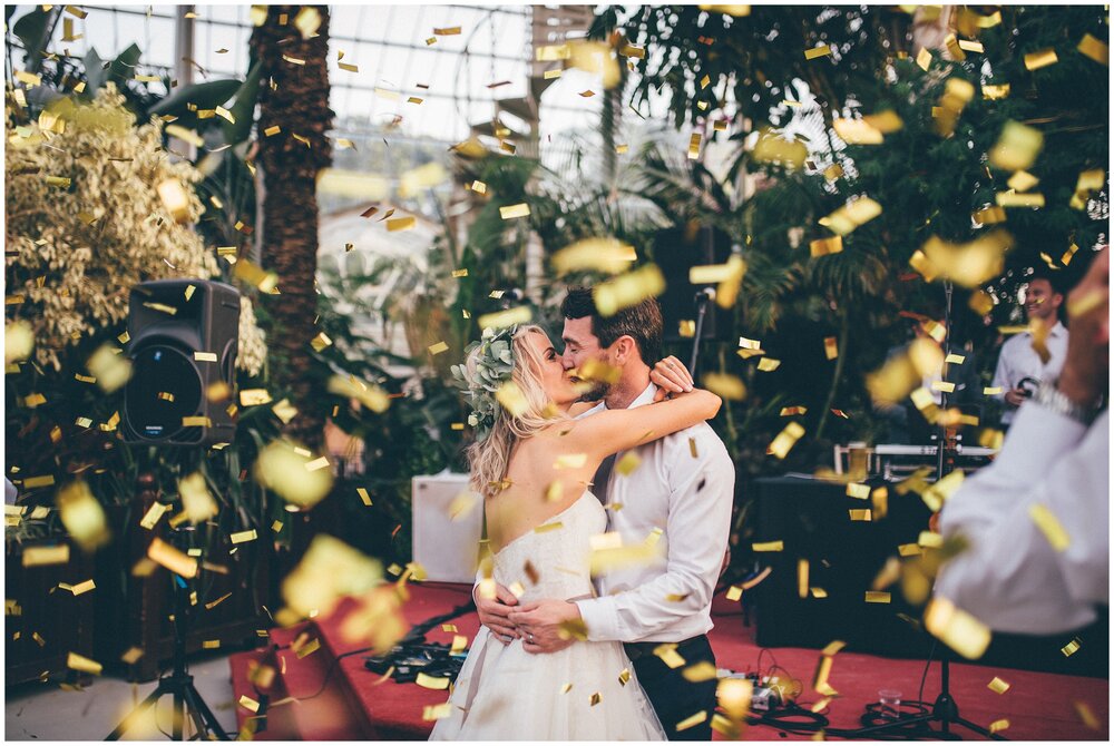 Gold confetti all over the bride and groom at their Sefton Palm House wedding in Liverpool.