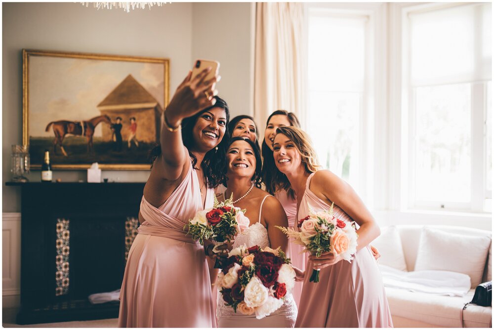 Brid and bridesmaids take a selfie at Chippenham Park Gardens wedding.