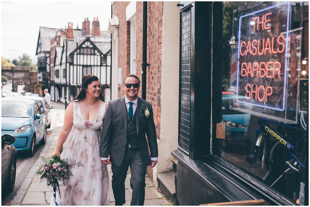 Bride and groom walk trough the streets of Chester on their wedding day after their Oddfellows wedding.