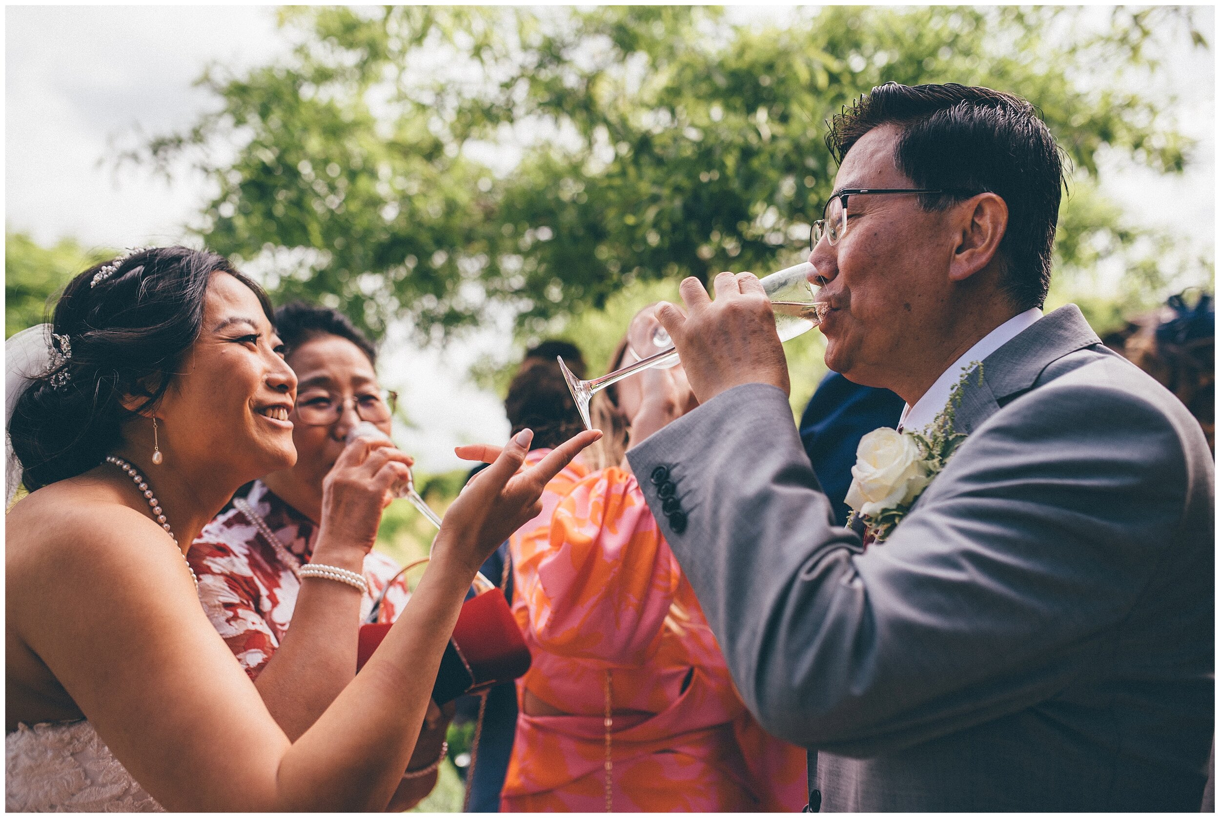 Bride encourages her dad to drink all of his champagne at her wedding at Chippenham Park Gardens.