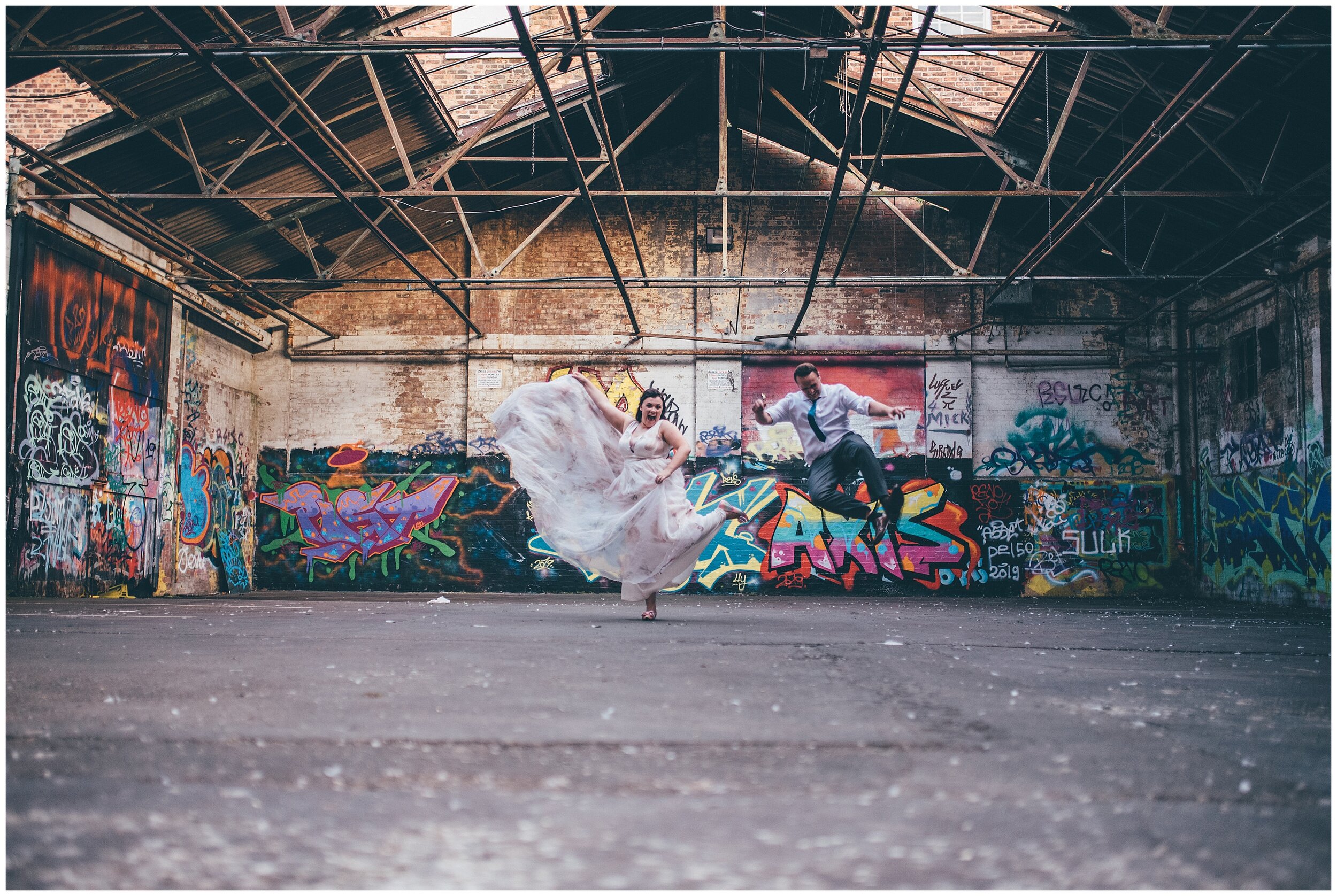 Newlyweds have playful and colourful wedding photographs in graffiti car park in Chester.