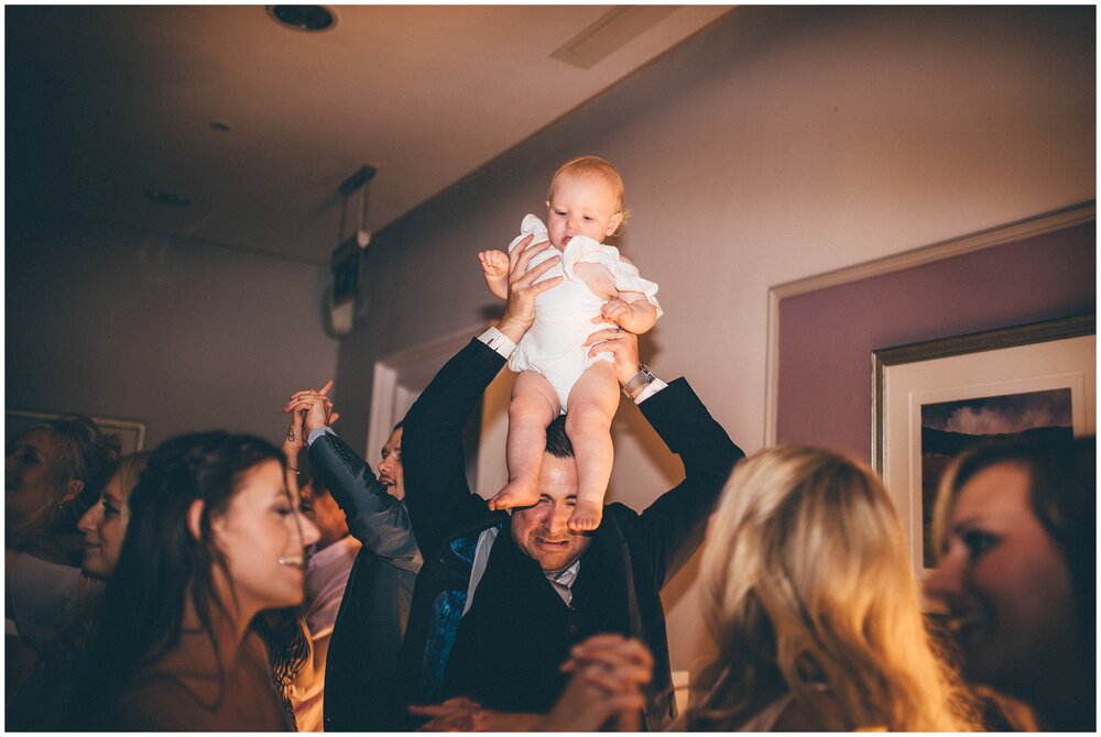 Groom struggles to get his daughter onto his shoulders during the danclefloor dancing at The Belsfield Hotel in Lake District.
