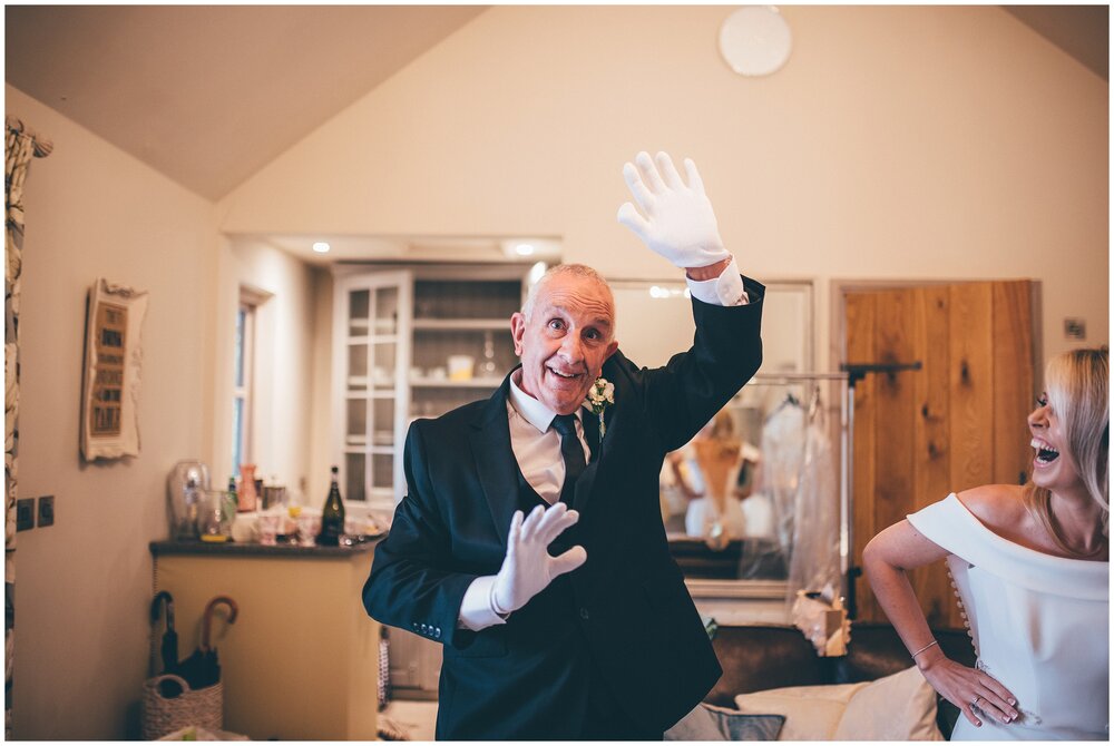 Bride's dad makes a joke before helping her into her wedding dress at Lemore Manor .