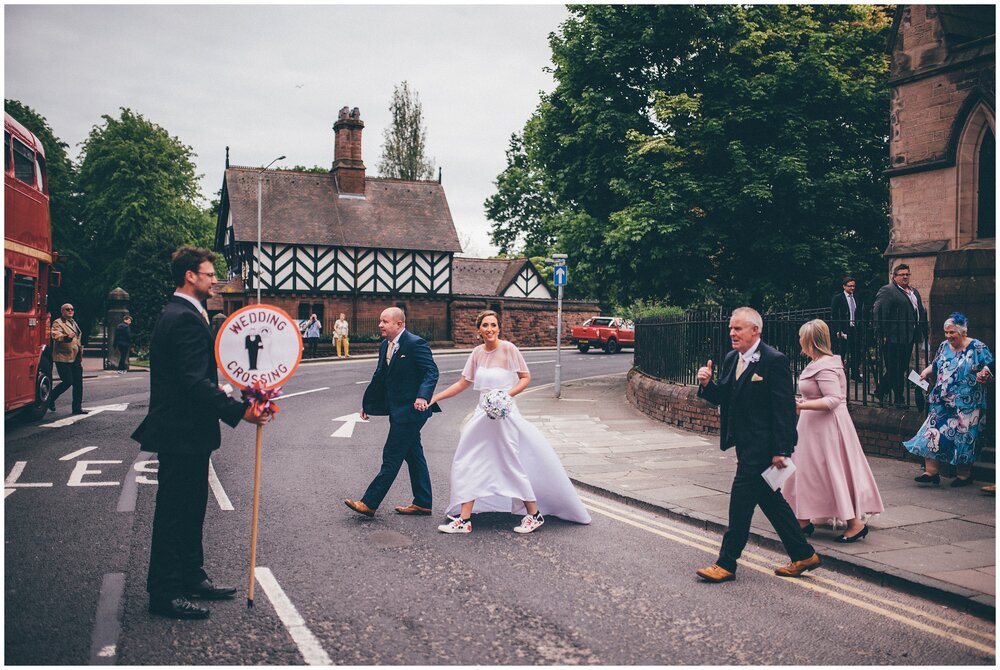 New husband and wife cross the road in Chester before their Las Vegas themed wedding reception at Chester Racecourse.