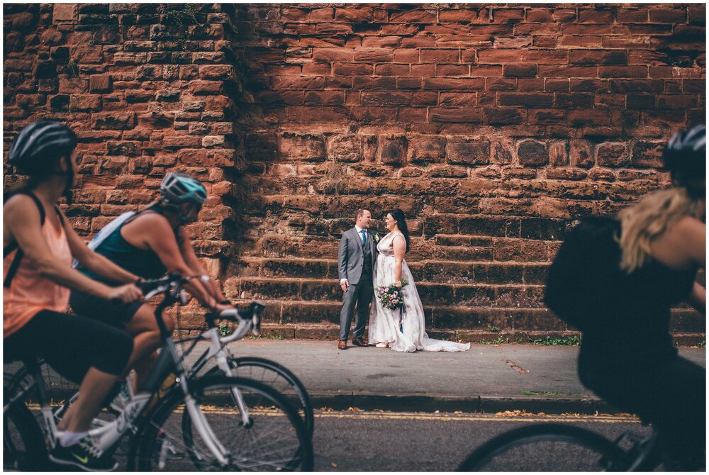 Cyclists look on at Bride and Grooms by the River Dee in Chester.