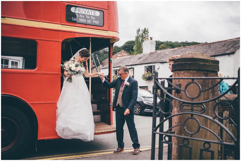 Bride's dad helps her off the double decker bus before her wedding in Frodsham in Cheshire.