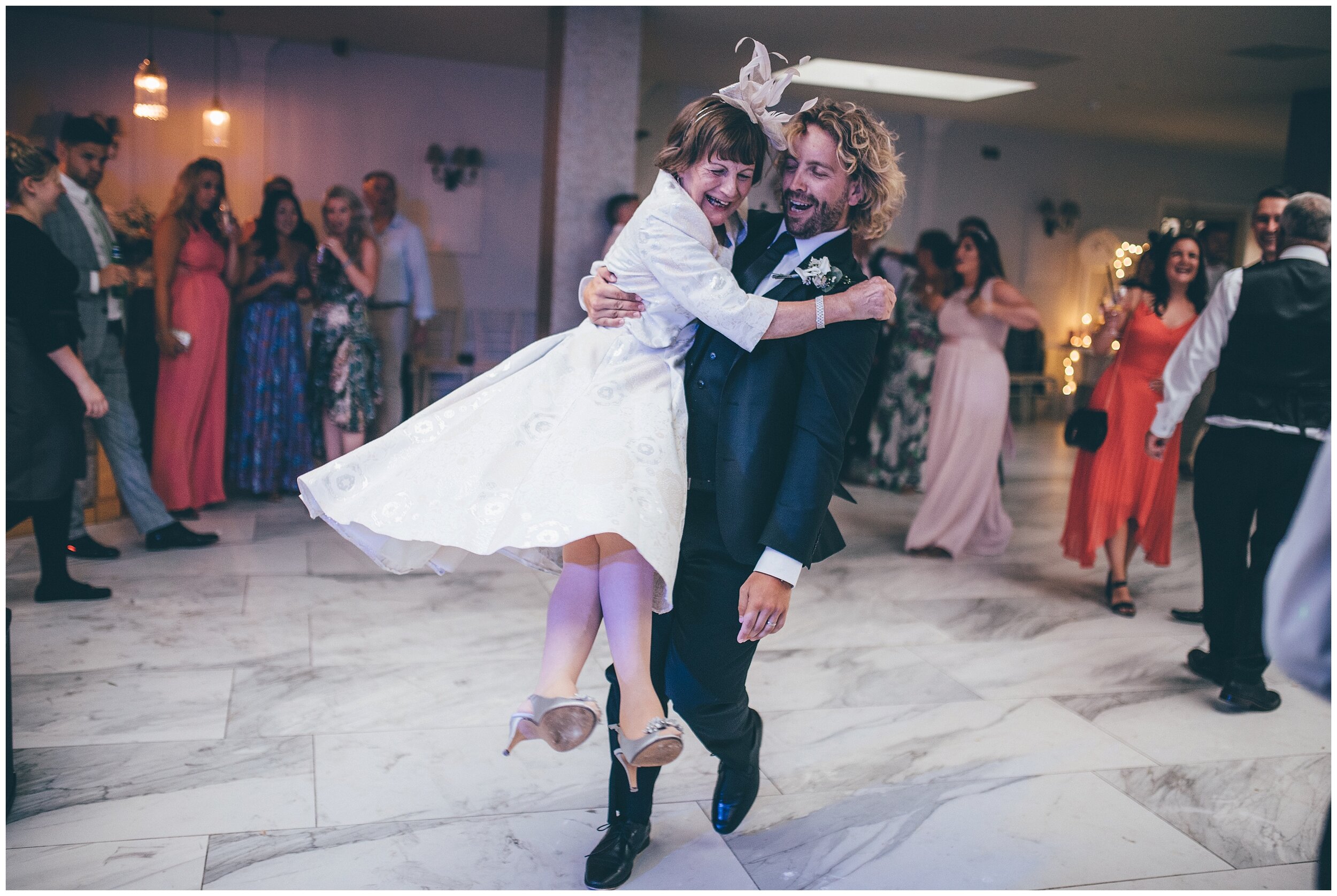 Wedding guest swings around Mother of the Groom at Lemore Manor wedding.