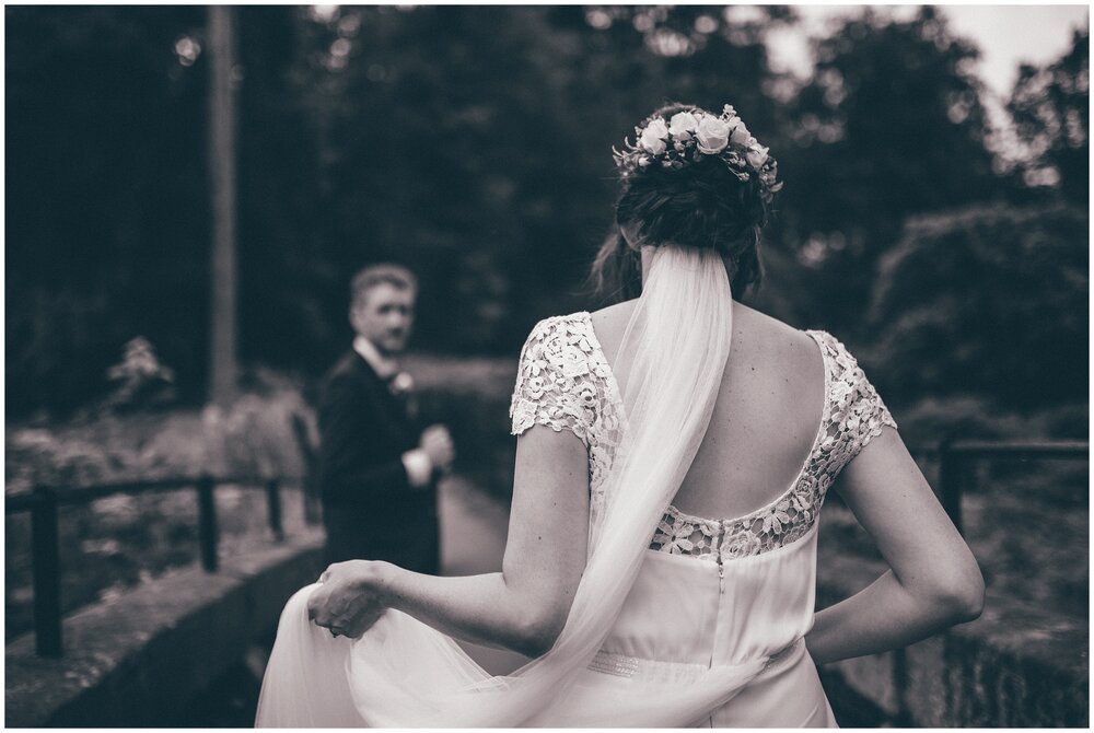 Black and white photograph of the back of the brides dress at Quarry Bank Mill in Cheshire.