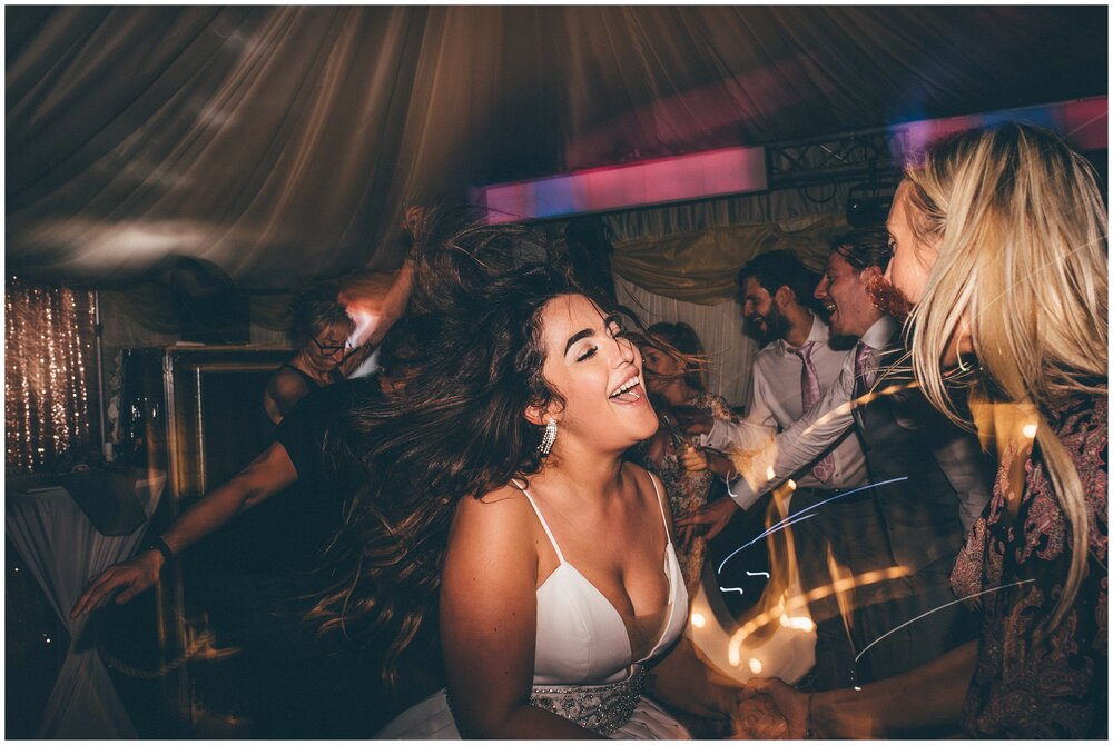 Bride whips her hair and dances at her wedding at Notley Tythe Barn.