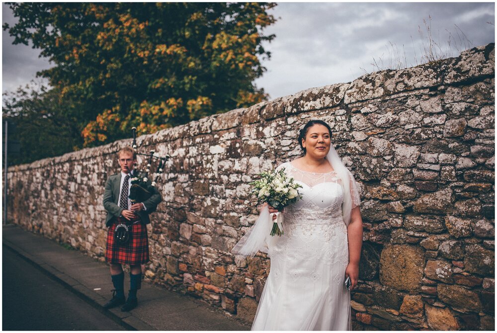 Bride after her intimate scottish wedding ceremony at Melrose Abbey with the bagpipes playing.