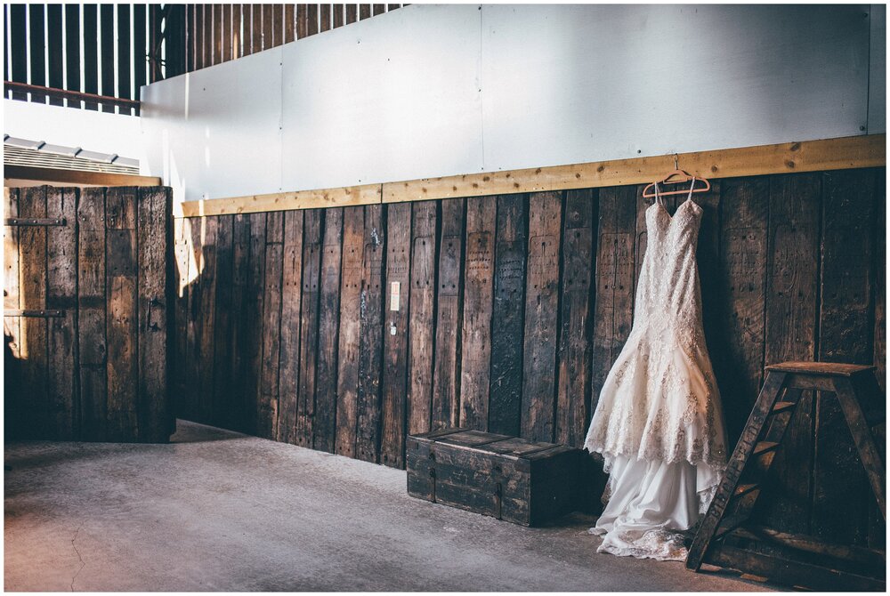 Beautiful wedding gown hung up at Owen House wedding barn.