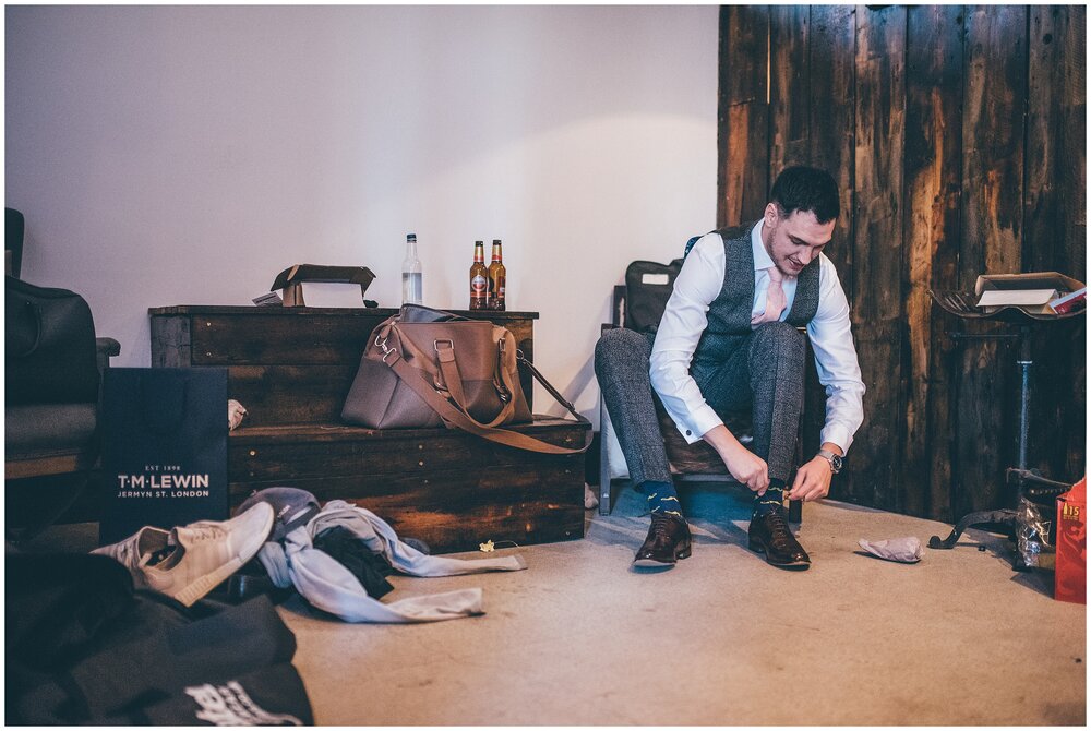 Groom gets ready on the morning of the wedding at Owen house wedding barn in Cheshire.