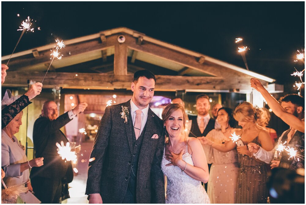 Bride and Groom enjoy the sparklers with their wedding guests at Owen House wedding Barn in Mobberly, Cheshire.