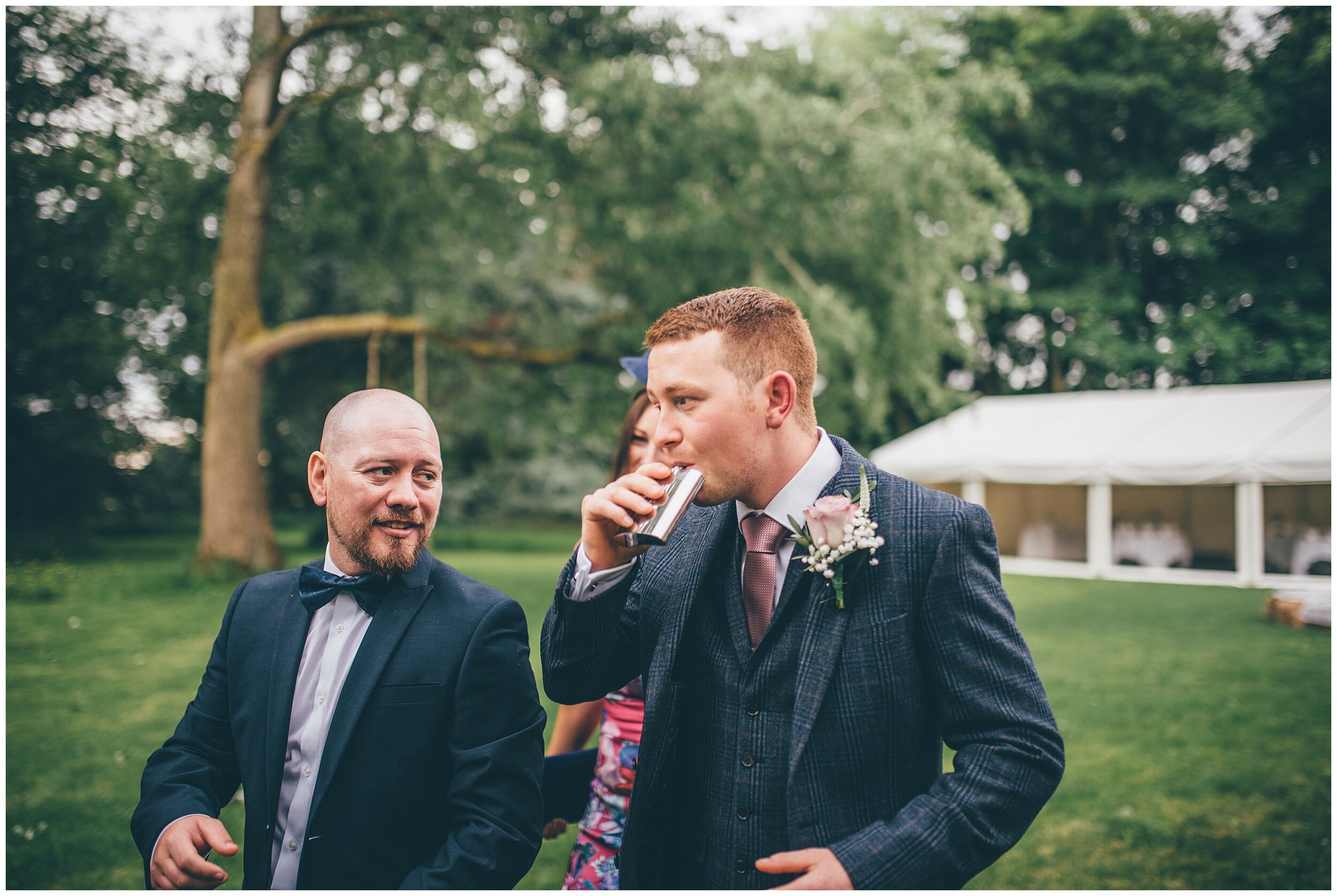 Groom drinks from a hip flask after his wedding ceremony at Chester wedding venue.